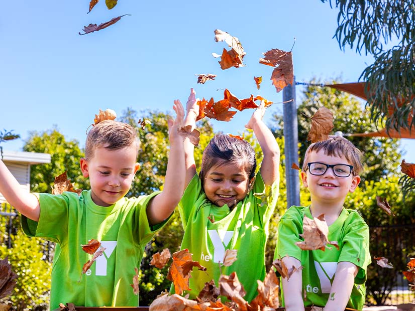 Children playing with autumn leaves