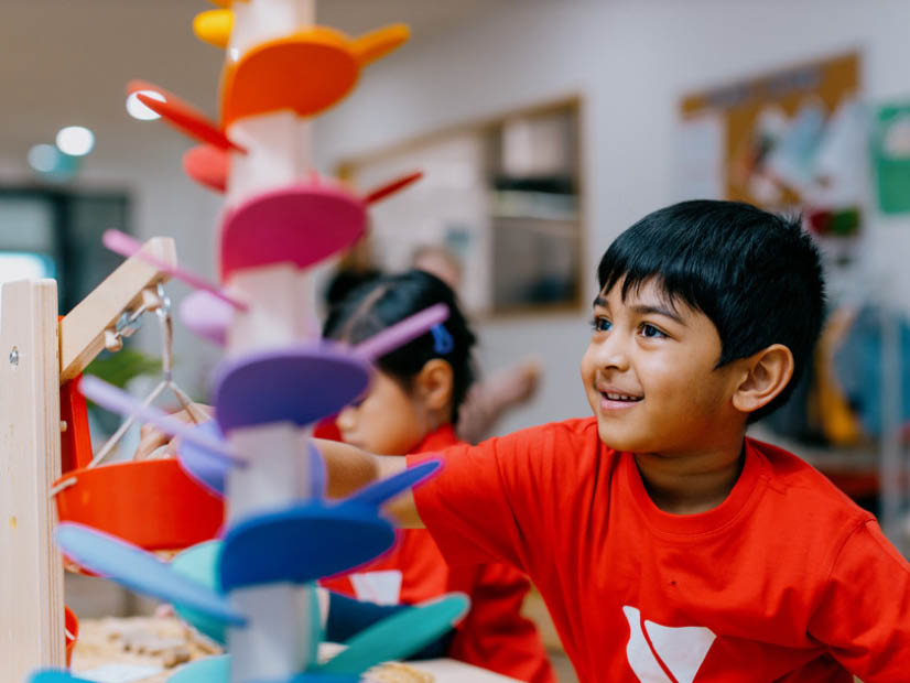 Child indoors playing balancing and problem solving game at the Y early learning centre